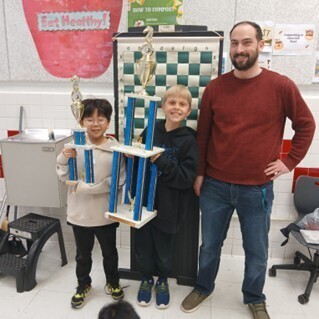 2 Churchill Road ES Chess Team members standing with VA Scholastic Chess Tournament Trophies