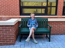 Student sitting on new bench on Dranesville ES campus