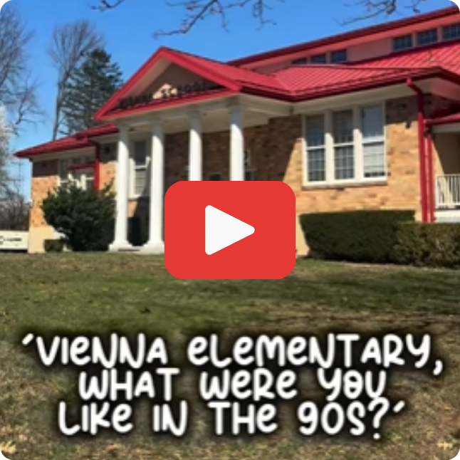 square image of front of school building with red and white play button on top