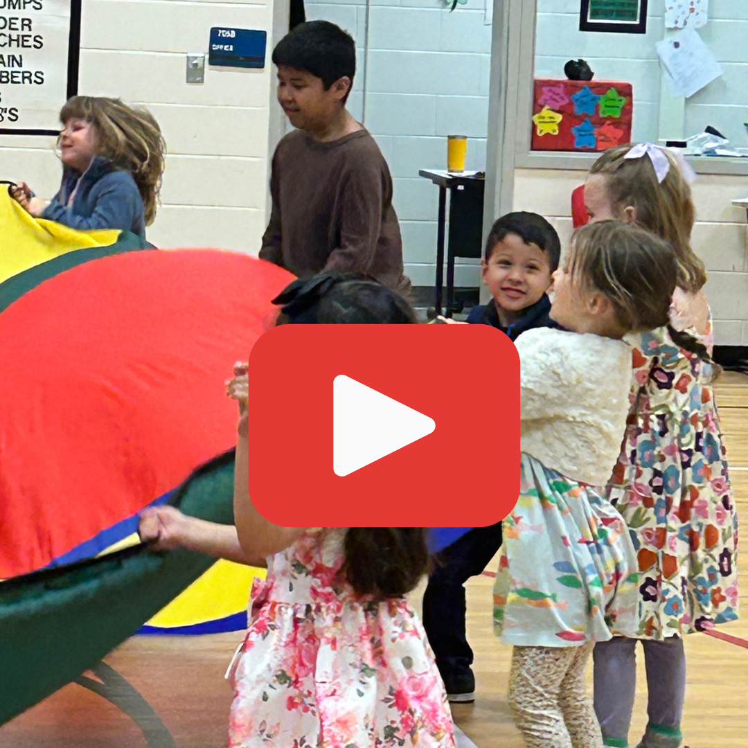 future kindergharteners playing parachute in a school gym