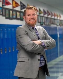 Assistant Principal Rob Plunkett standing in a school hallway