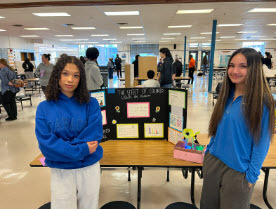 students smiling in front of their science projects