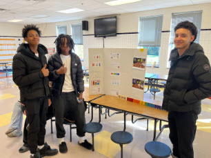 students smiling in front of their science projects