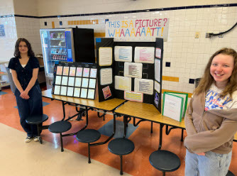students smiling in front of their science projects