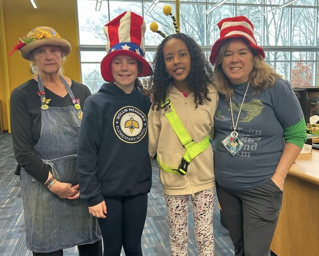 Ms. Springer, Mrs. Tucker, and 2 students wearing hats or headbands for the Read Across America spirit week.