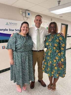 Three FCPS administrators and staff smiling in the hallway.