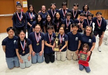 Students and teacher wearing medals around necks and holding trophy
