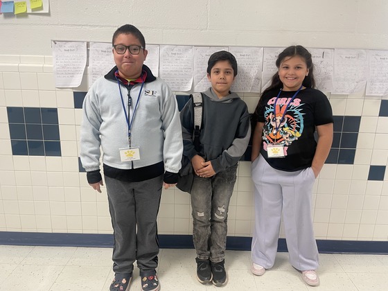 Three students in the hallway. 