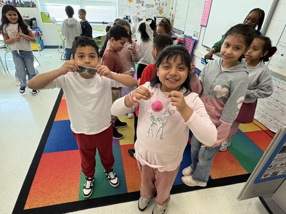 Students holding up their attendance prizes. 
