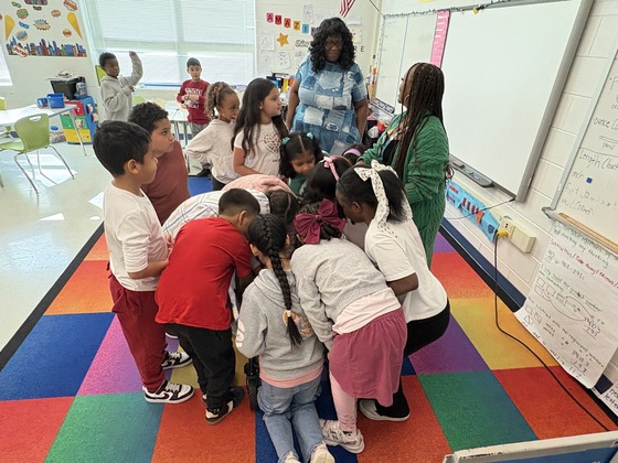 Students huddled around a prize box. 
