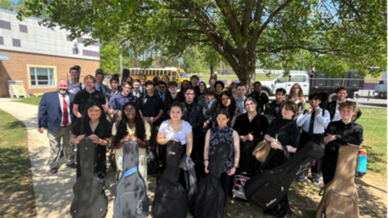 Picture of the guitar students standing outside under a tree
