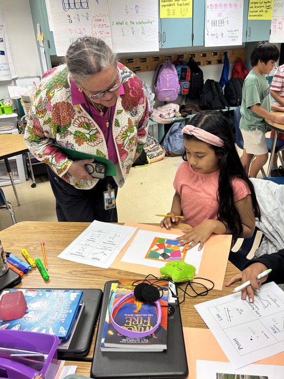4th grader explaining her geometry project to Dr. Reid