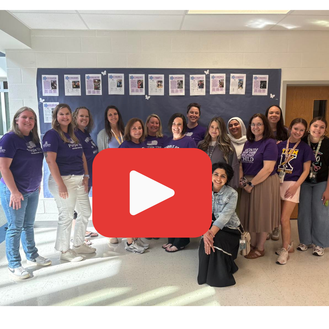 Group of staff wearing purple shirts standing in a school hallway to support military-connected students.