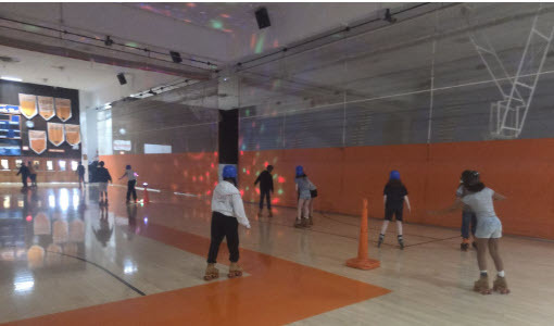 students rollerskating in a dark gym