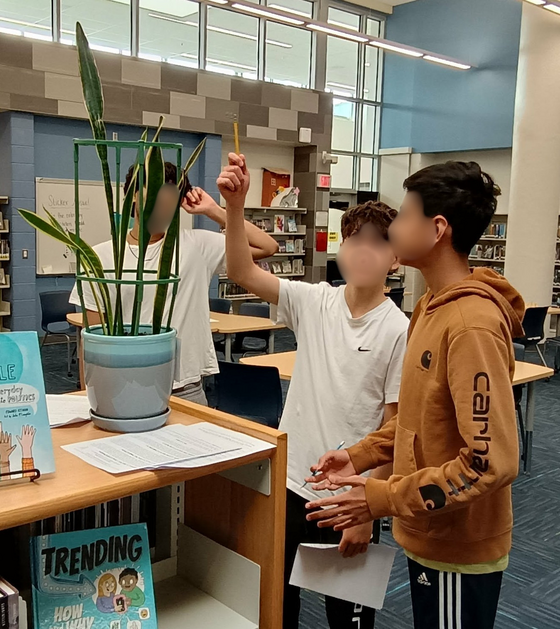 Science students working in the library observing plants