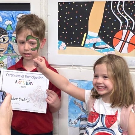A picture of a Stenwood student receiving a certificate for participating in the Marshall Pyramid Art Show