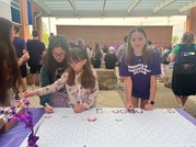 Students drawing their self portrait for Month of Military Child at annual Donuts with Dependents