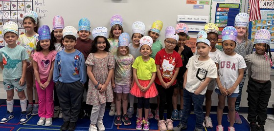 Mrs. Hanrahan's first grade class wearing paper hats that they made to celebrate Month of the Military Child.