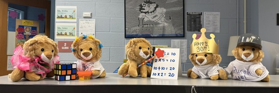stuffed lions dressed in spirit days wear (beach, baseball, birthday crown, and Lane shirt with math cards)