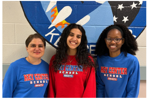 three admin assistants standing side by side in blue and red shirts