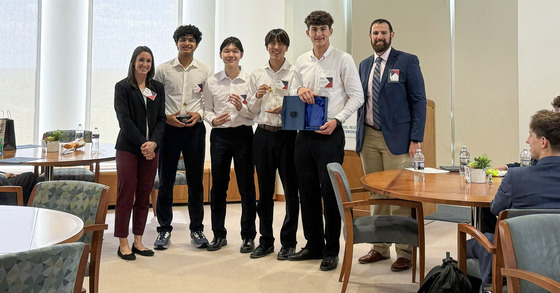 TJ's first place team at Econ Challenge State Final poses with their championship medals, which are little stars.
