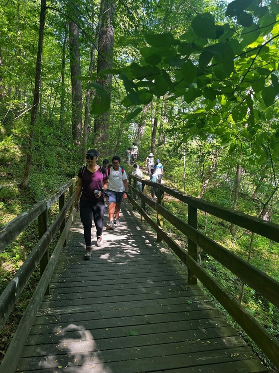 Outdoor club members crossing a bridge 