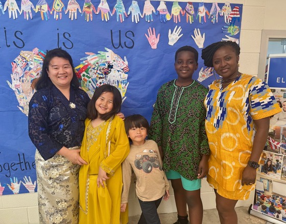 Two families standing in front of This Is Us Poster