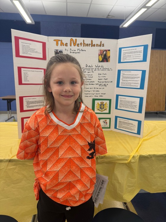 Student in front of a three sided poster about the Netherlands