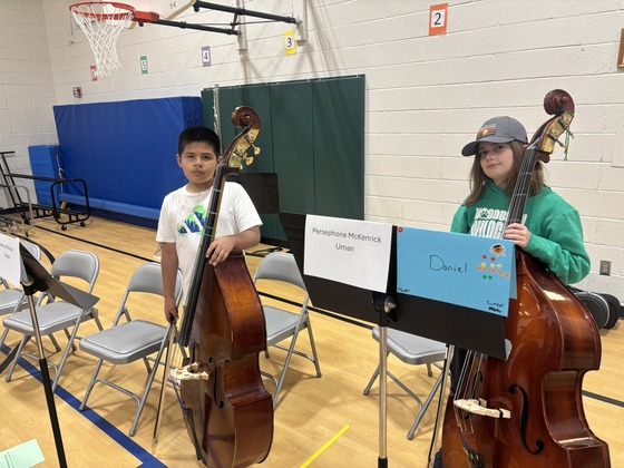 Students hold upright bass at strings concert 