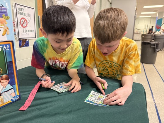 Two students look at bingo cards 