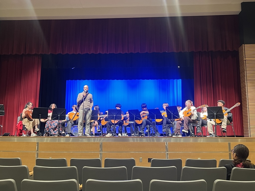 Students performing with instruments on stage for their school concert