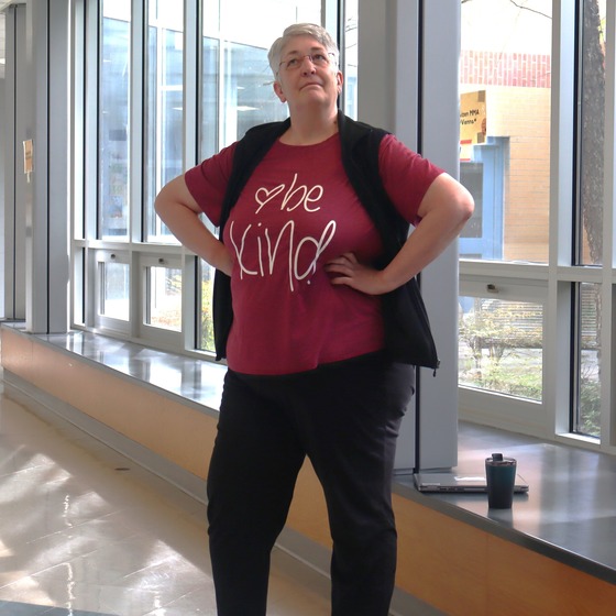 Picture of a teacher, Ms. Roth, posing in her Bee Kind spirit shirt.