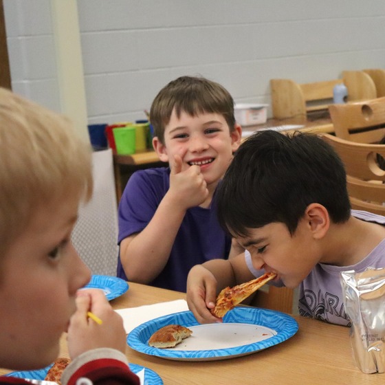 A second picture of a table of students eating pizza after receiving their CARES Pizza award for responsibility