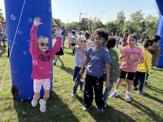 Students celebrating surrounded by bubbles at the fun run