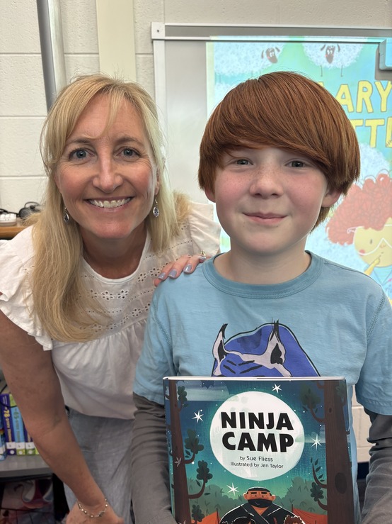 Author Sue Fliess with a 4th grade student who is holding one of her books.
