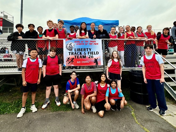Liberty's track and field team posing with their team poster