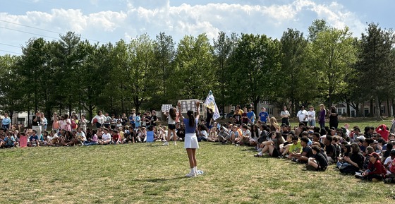 Students gathered on the field for the testing pep rally, with SCA leaders holding cheer signs