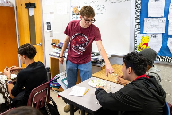 teacher working with students on a project