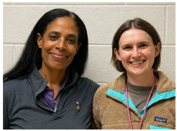 Hearing Impaired teacher and Audiologist, standing next to each other, one in blue top and the other in tan top, both smiling