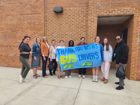 People holding a blue banner that reads "Thank you WSHS Bus Drivers"