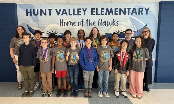 HVES science olympiad team standing in frond of the school mural
