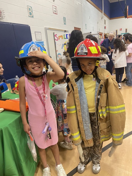 EMT students help elementary students try on fire and rescue gear