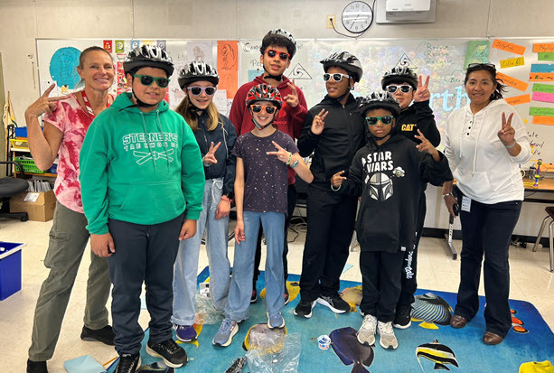 Group photo of students wearing bike helmets.  They had just learned about bicycle safety.