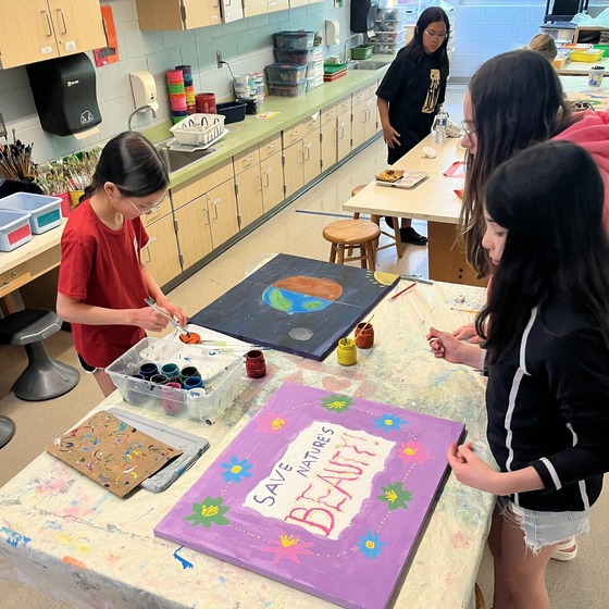 A picture of 2 students making a poster for Earth Week