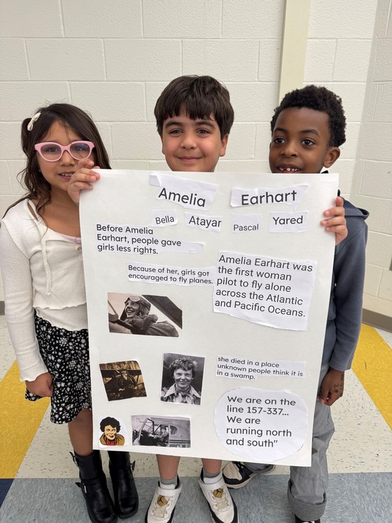 Students holding a poster about a change maker.