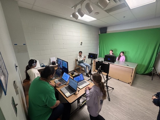 Students sit in the news room
