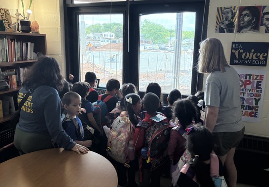 PreK students looking out of the window at construction
