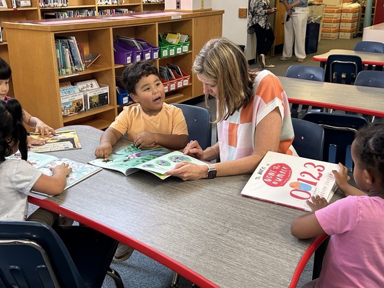 PreK student and teacher reading together