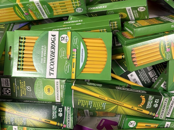 A bin overflowing with green boxes of Ticonderoga Number 2 HB yellow pencils.
