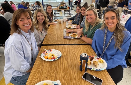 Teachers sitting at a table eating breakfast provided by the school PTO
